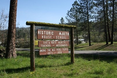 A brown wooden sign with the words 'Historic McBeth House β School.'